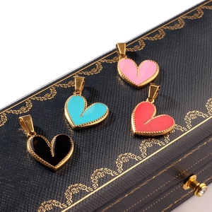 Vintage heart pendants in pink, teal, red and black with gold edges on a retro jewelry box