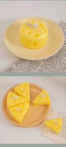 Detailed view of cheese shaped scented candles in whole and sliced styles on tray