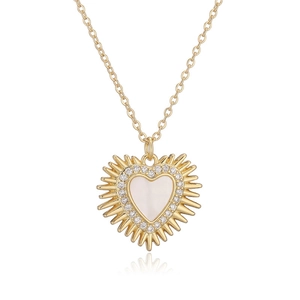 Detail of gold heart pendant with white shell inlay and zircon sunburst halo