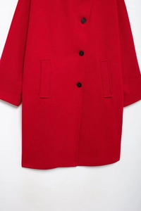 Macro detail of red wool coat with black buttons and functional side pockets