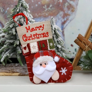 Detail of red Christmas stocking with Merry Christmas embroidery and 3D Santa Claus figure