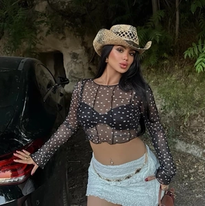 Outdoor street style shot of black polka dot sheer mesh long sleeve crop top for women