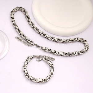 Close-up of silver Byzantine chain necklace and bracelet set on white display stands
