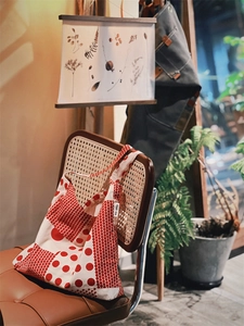 Détail artistique d'un sac en toile à pois rouges et blancs sur une chaise vintage