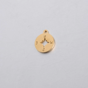 Detailed close-up of golden compass pendant with cut-out star and engraved directions