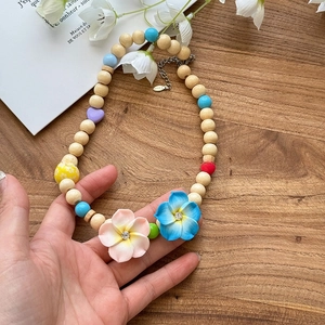 Bohemian beaded necklace detail featuring colorful floral pendants and wooden beads
