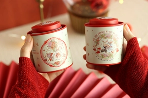 Close-up of mini bunny motif wedding favors tins held in hands for gift display