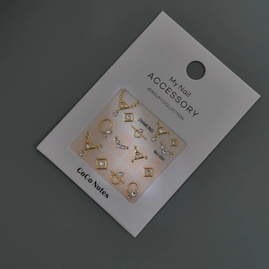 Détail de bijoux d'ongles 3D dorés avec strass sur carte de présentation MJ-050