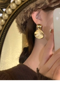 Détails de boucles d'oreilles dorées avec disque en métal martelé et petit clou boule