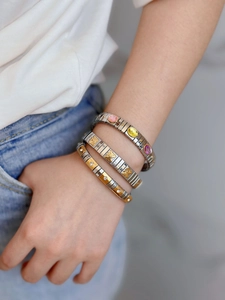 Detailed shot of stackable stainless steel bracelets with butterfly and colorful gemstones