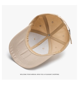 Inside view of beige baseball cap showing 6-panel structure and adjustable metal buckle