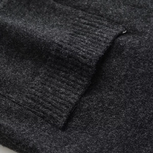 Sleeveless V-neck knit sweater vest in dark grey featuring ribbed hem and pocket details