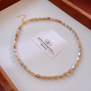 Detail of amber bead necklace with golden adjustable chain and elegant lobster clasp