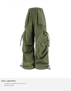 Dettaglio dei pantaloni cargo verde militare con tasche a patta e fondo gamba con coulisse