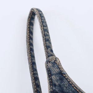 Macro detail of the double-stitching and denim fabric texture on the shoulder strap