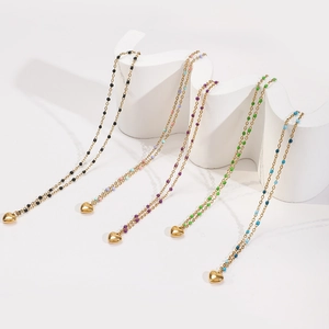 Collier avec pendentif cœur en acier inoxydable doré et perles colorées sur un présentoir