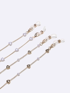 Golden eyewear chains with heart beads and faux pearls on white background