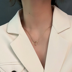 Minimalist twisted heart pendant necklace in gold finish on model for women