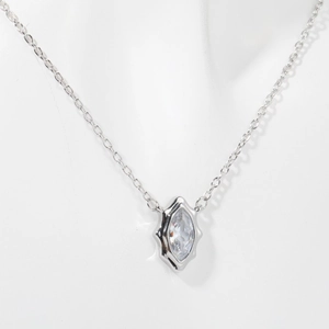 Detail of silver geometric pendant with marquise-cut zircon on a delicate link chain