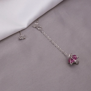 Detail view of asymmetric silver earrings featuring a diamond cloud and purple umbrella charm