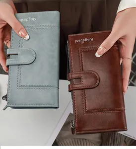 Detail showing blue and brown long wallets with zipper and buckle held in hand