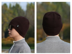 Close-up of deep brown knitted beanie with thick vertical stripes and brand label detail