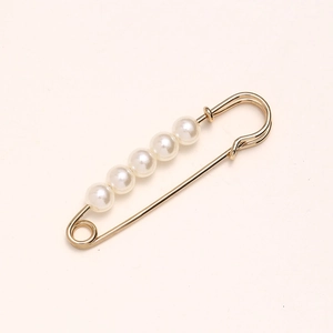 Close-up of gold metal waist pin brooch featuring five elegant white pearls