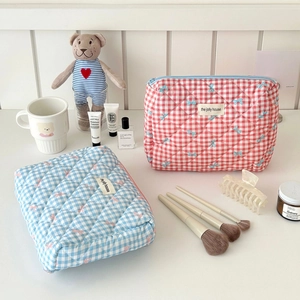 Quilted checkerboard cosmetic bags with bow prints in red and blue, featuring top zipper
