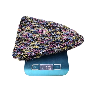 Primo piano di un cappello da pescatore in maglia colorata con peso di 110g sulla bilancia