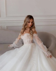 Detail of white off-shoulder bridal gown with lace embroidery and sequins on the bodice
