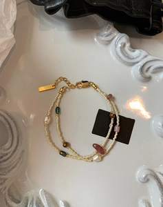 Macro shot of double-layered freshwater pearl bracelet with gold hardware on white tray