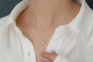 Close-up of S925 silver necklace with rectangular zircon pendant worn by a model
