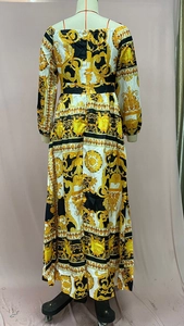 Back view of elegant baroque print maxi dress with long sleeves on a mannequin stand