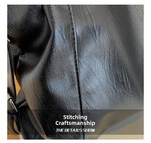 Close-up of black leather tote bag showing fine stitching and lychee grain texture