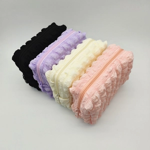 Quilted bubble texture cosmetic bags set in four soft pastel colors with zipper closures