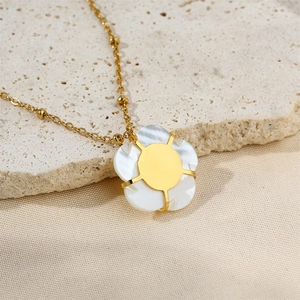 Macro detail of gold-plated shell flower pendant and delicate bead chain necklace