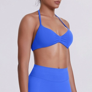 Detail of high-stretch halter sports bra in bright blue with pleated chest design