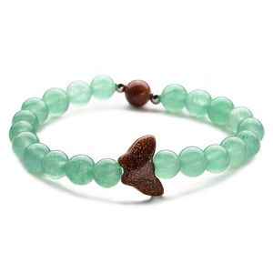 Macro detail of natural stone beaded bracelet with carved goldstone butterfly pendant