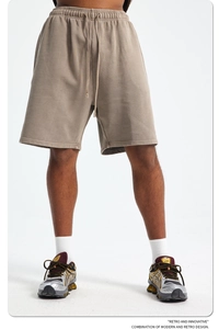 Detail of khaki drawstring waist and knitted cotton texture on men's retro shorts