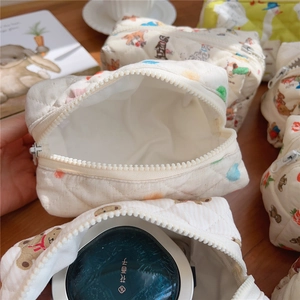 Detailed macro view of quilted cotton makeup bags with cute bear prints on a wooden desk