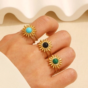 Close-up of vintage sunflower rings with turquoise gemstones on gold bands