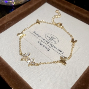 Close-up of golden butterfly bracelet with cubic zirconia on velvet jewelry box liner