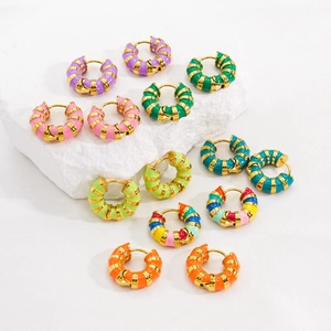Colorful enamel striped gold hoop earrings in assorted vibrant colors displayed on stones