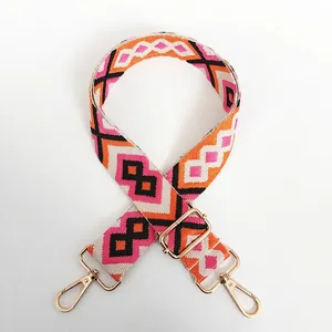 Detail of colorful geometric diamond pattern woven canvas bag strap with gold lobster clasps