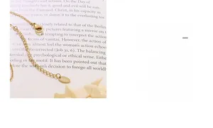 Close-up of the K18 engraved tag and lobster clasp on a gold plated necklace