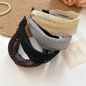 Detailed close-up of woven wide headband texture in beige, gray, black, and caramel colors