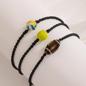 Detail view of woven sports bracelets featuring volleyball, tennis, and rugby charms