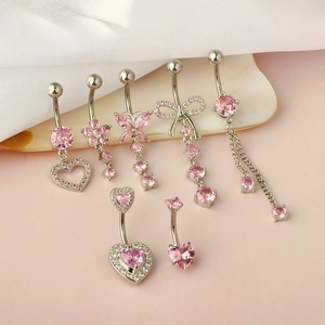 Detail view of 7-piece belly ring set with pink zircon on a ceramic tray