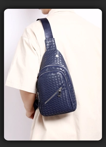 Detailed side view of woven navy blue faux leather sling bag for men on model