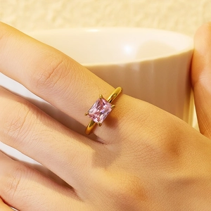 Detailed view of an 18K gold plated ring with a pink rectangular gemstone on a model hand